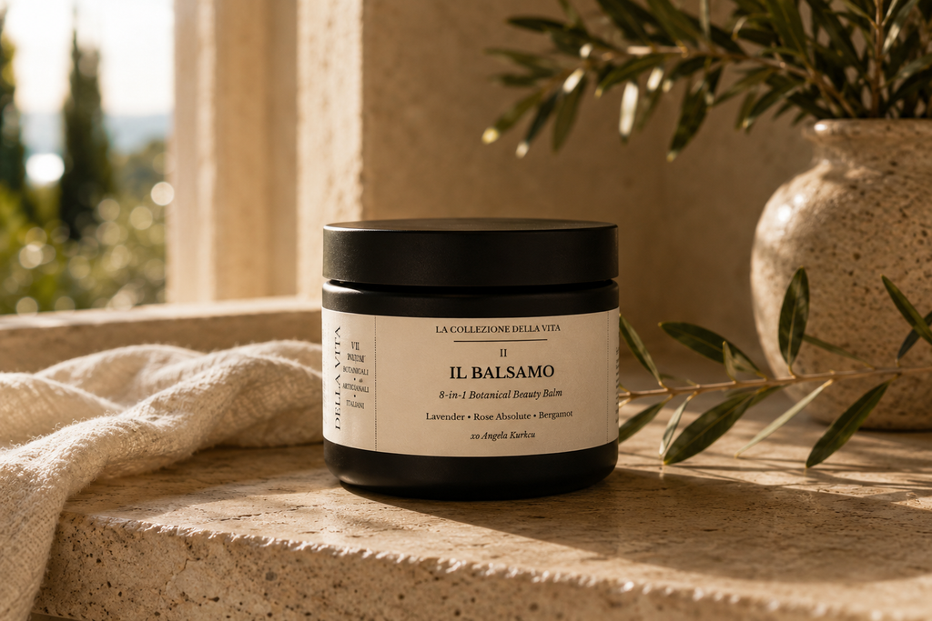 Il Balsamo 8-in-1 Botanical Beauty Balm jar on travertine with olive branch
